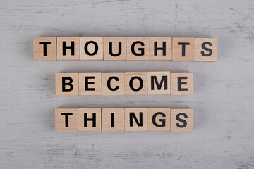 wooden cubes showing the words thoughts become things