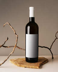 Blank white label mock up on black bottle of unlabeled wine on a table. Alcohol bottle mockup...