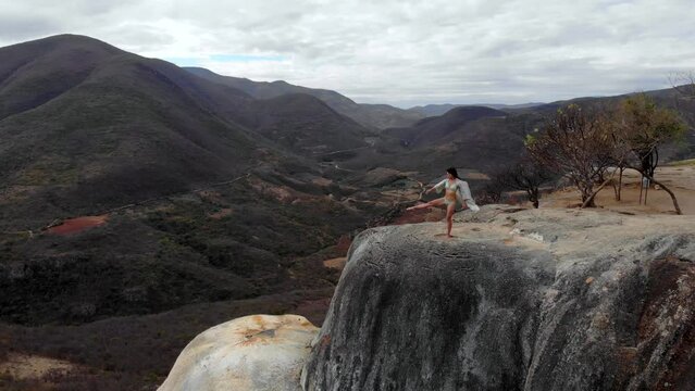 Aerial Drone Shot Asian Girl Dancing on the Edge of Natural Petrified Waterfall Hierve el Agua in Mexico, Oaxaca. 