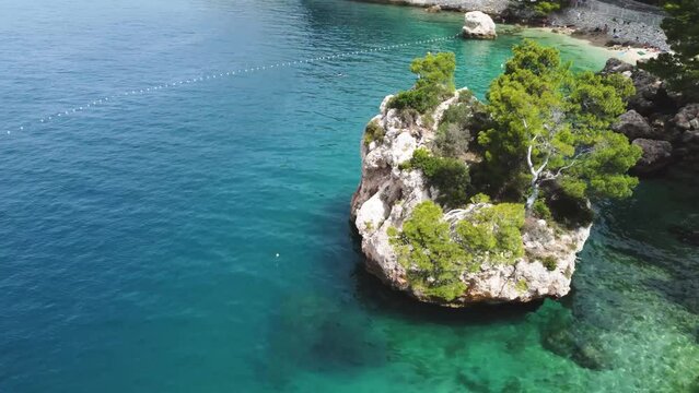 Aerial view in Brela Stone, Kamen Brela - a symbol of Brela, a popular natural attraction in Croatia. Beautiful sunset view of Brela Stone, Punta Rata beach, Makarska riviera of Dalmatia, Croatia. 4k.