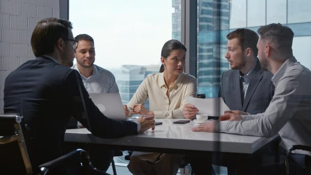 Serious mature businesswoman discussing workflow with colleagues