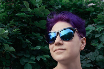 Gen z lifestyle concept. Handsome confident girl with purple hair in goggles with copy space.