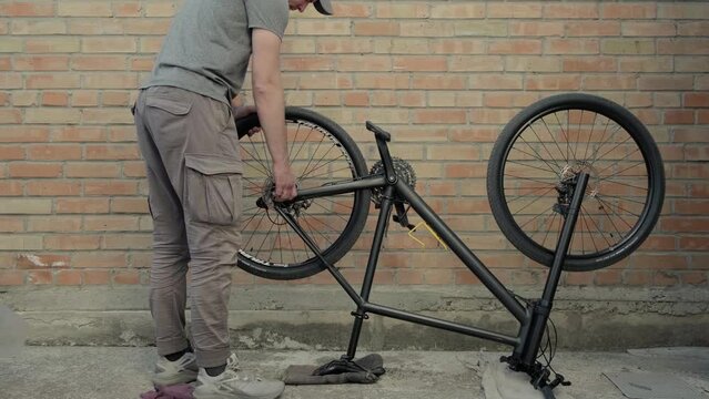 Mechanic repairing a bicycle. Specialist attaching a bicycle wheel to a bike frame. Bike service and care concept