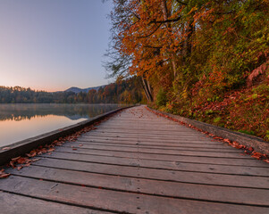 Wooden pier at lake Bled in the early morning. Beautiful and calm destination for a morning walk.