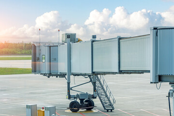 Empty aircraft parking passenger air bridge at airport apron against the backdrop of a beautiful...