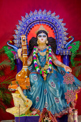 Obraz premium Idol of Goddess Saraswati with veena, a musical instrument and white swan, a sacred bird, at Kolkata, West Bengal, India. Saraswati is Hindu goddess of knowledge, music, art, wisdom, and learning.