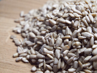 Heap of sunflower seeds on a wooden surface close-up.