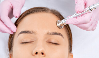 Procedure microdermabrasion on the face against acne and blackheads. Women's cosmetology in the beauty salon.