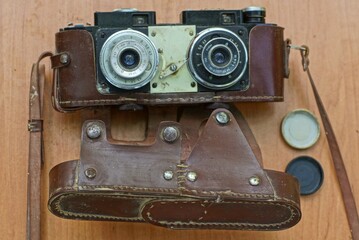 a very old classic iron film camera in an old brown leather case for stereoscopic shots