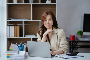 Happy smiling business woman using laptop for working and study at home or office space.