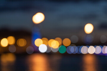 blurred lights of a big city at night, reflection of lights in river water, night cityscape
