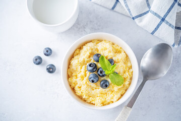 Corn porridge with fresh blueberries in a bowl