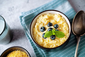 Corn porridge with fresh blueberries in a bowl