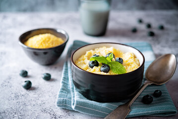 Corn porridge with fresh blueberries in a bowl