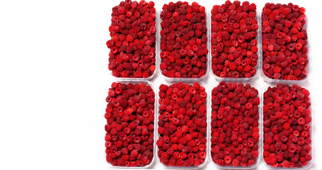 Ripe red fragrant raspberries collected in a farm in a transparent container for sale.