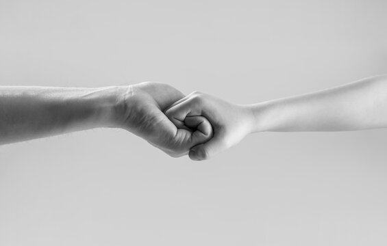 Woman and kid hands connect with each other. Friendly handshake, friends greeting. Rescue, helping hand. Man help hands, protection. Male and child hands connected each other together and forever