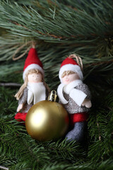 christmas elves - a boy and a girl with christmas gift on fur tree brunches. Winter concept. Horizontal image