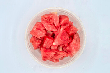 TOP VIEW OF FRESH SEEDLESS WATERMELON IN PIECES INSIDE A PLASTIC LUNCH BOX