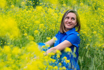 Naklejka na ściany i meble girl in yellow flowers in a blue dress
