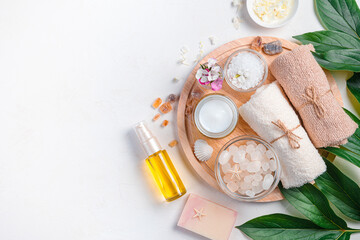 Spa composition with oil, cream and spa accessories on a light background. Top view, copy space.