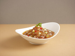 marinated jellyfish with vinaigrette served in a dish isolated on background side view