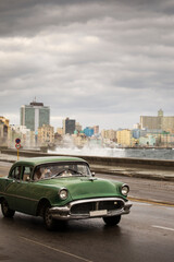 Old car on Malecon street of Havana with storm clouds in background. Cuba