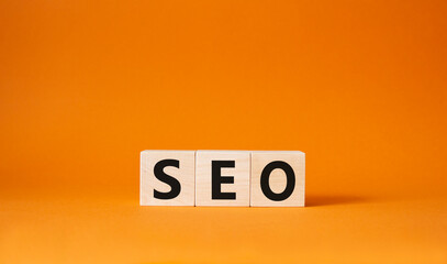 Seo symbol. Wooden blocks with words 'Seo'. Beautiful orange background. Business and seo concept....