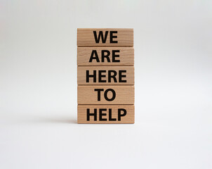 We are here to help symbol. Concept words we are here to help on wooden blocks. Beautiful white background. Business and we are here to help concept. Copy space.