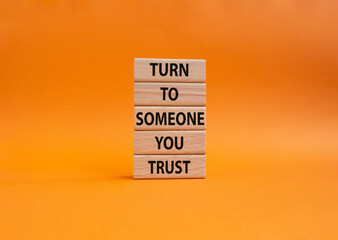 Turn to Someone you trust symbol. Wooden blocks with words Turn to Someone you trust. Beautiful orange background. Business and Turn to Someone you trust. Copy space.