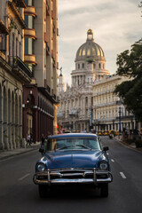 Fototapeta na wymiar Old car on streets of Havana with Capitolio building in background. Cuba