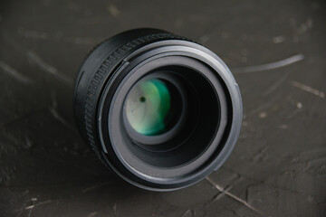 Lens on a dark gray background. The concept of using photographic equipment
