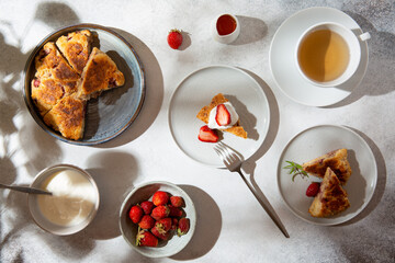 British scones with cream and strawberry.  Homemade strawberry scones cut in triangles on gray...