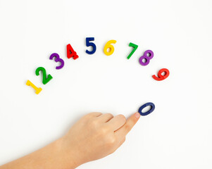 The child uses his index finger to move the number zero up. Early education. We learn colors and count from zero to ten