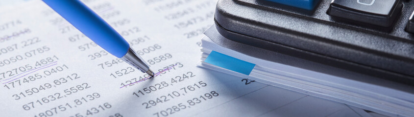 Accounting document with pen, money, coins and checking financial chart. Concept of banking, financial report and financial audit.