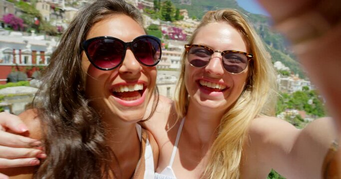 Two women pouting while taking selfies together on holiday