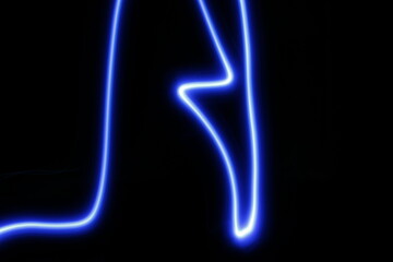 Luz de neòn color azul en movimiento y desenfoque muestra un garabato de formas elìpticas y geomètricas, presenta un original y ùnico diseño abstracto con fondo negro