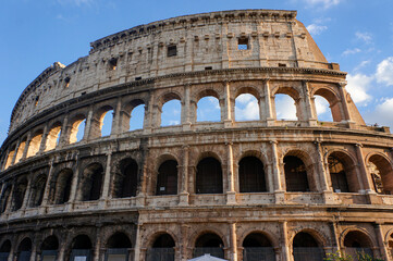 Detail view of ancient Colosseum landmark of Rome, Italy, on a sunny and partly cloudy summer day.