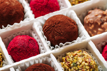 A set of truffle sweets with different fillings in a box close-up