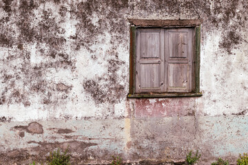 Casa antigua con textura, con ventana de madera vieja, con pared color blanco y rojizo