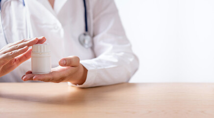 Healthcare and medical concept. Medicine doctor with stethoscope holding pills bottle in hands. Physician and pharmaceutical industry. Physician. Pharmacy. Copy space