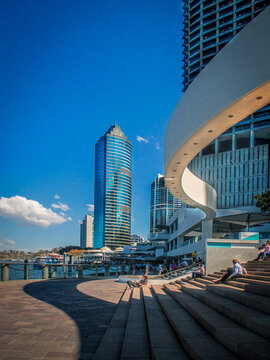 08-14_2014 Brisbane Australia- People sitting on steps near the river with views of CBD skyscrapers and architecure in Brisbane