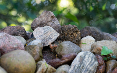 Stacked fieldstones isolated against a blurred background. Natural stone background with isolated edge. Stones in close-up.