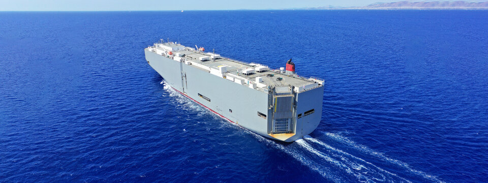 Aerial drone ultra wide photo with copy space of Large RoRo (Roll on-off) car cargo ship cruising the Mediterranean deep blue sea