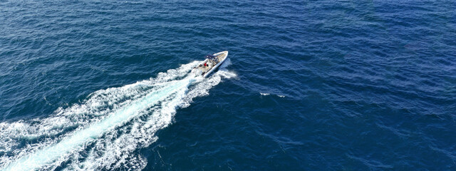 Aerial drone ultra wide photo with copy space of luxury rigid inflatable speed boat cruising in high speed in Aegean deep blue sea, Greece