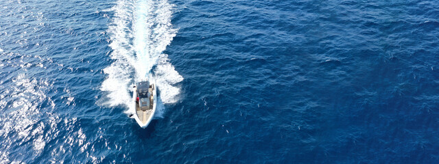 Aerial drone ultra wide photo with copy space of luxury rigid inflatable speed boat cruising in...