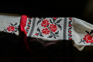 Fragment of Ukrainian national dress. Vyshyvanka - ethnic clothing with embroidery patterns. red and black threads. Close-up shot, copy space.