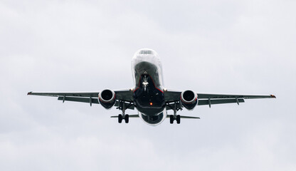 Passenger plane comes in for landing in cloudy weather.
