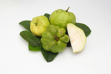 a group of fresh ripe Crystal guava (Psidium guajava) on green leaves isolated on white background.