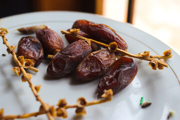 Close-up view of ripe date palm fruit on white plate is ready to eat