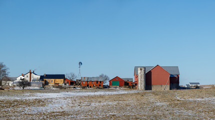 Fototapeta na wymiar Amish farmstead in late winter among snowy fields under a clear blue sky | Amish country, Ohio